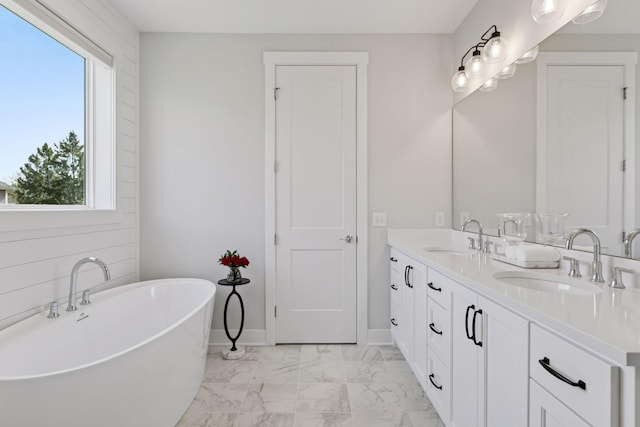 full bath with marble finish floor, a healthy amount of sunlight, and a sink