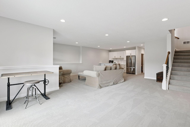 living area with light carpet, baseboards, and recessed lighting