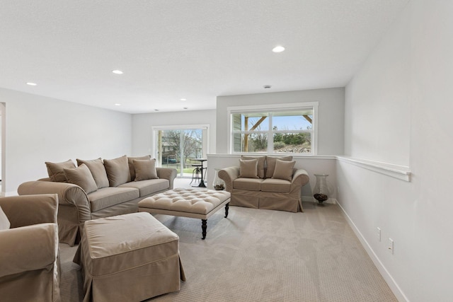 living room featuring light carpet, baseboards, and recessed lighting