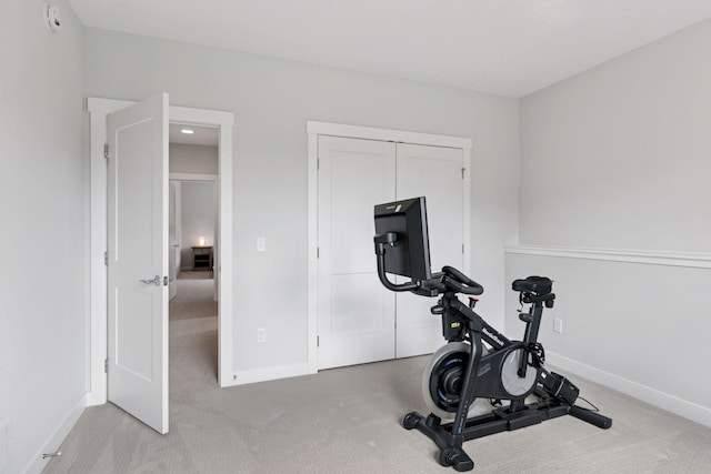 workout room featuring baseboards and carpet