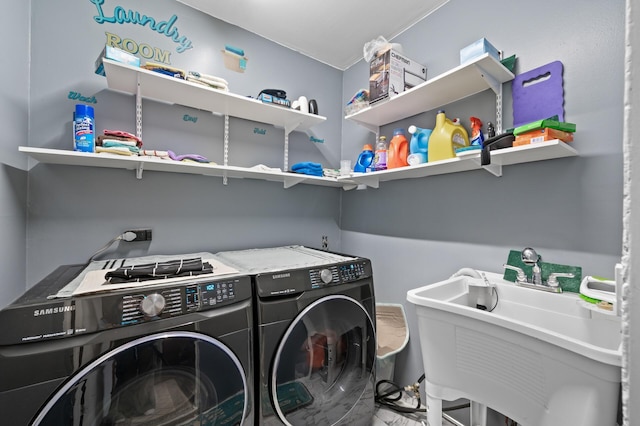 clothes washing area featuring a sink, washing machine and dryer, and laundry area