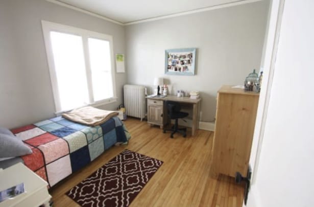 bedroom featuring crown molding, radiator heating unit, and wood finished floors