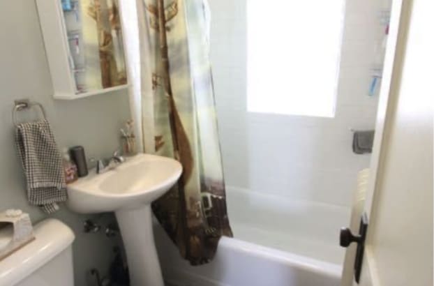bathroom featuring shower / bath combination with curtain and toilet