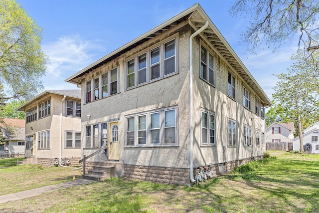 386 Fry St, Saint Paul, MN 55104 - back of property with entry steps, stucco siding, and a yard