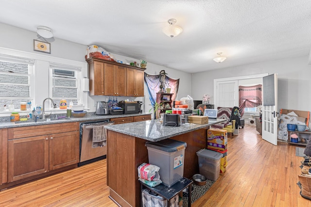 386 Fry St, Saint Paul, MN 55104 - kitchen featuring stainless steel dishwasher, a sink, light wood-style floors, french doors, and dark stone counters