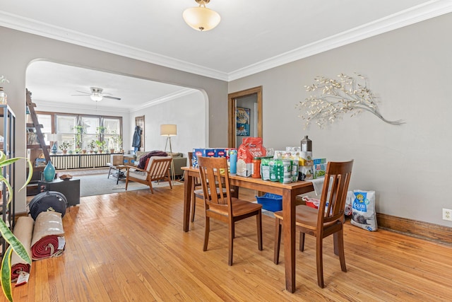382 Fry St, Saint Paul, MN 55104 - dining area featuring arched walkways, light wood finished floors, crown molding, and a ceiling fan