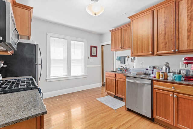 382 Fry St, Saint Paul, MN 55104 - kitchen featuring stainless steel appliances, a sink, light wood finished floors, and stone countertops