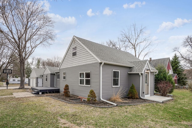 view of home's exterior featuring roof with shingles and a yard