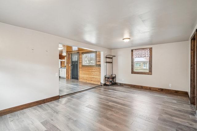 spare room featuring baseboards and wood finished floors