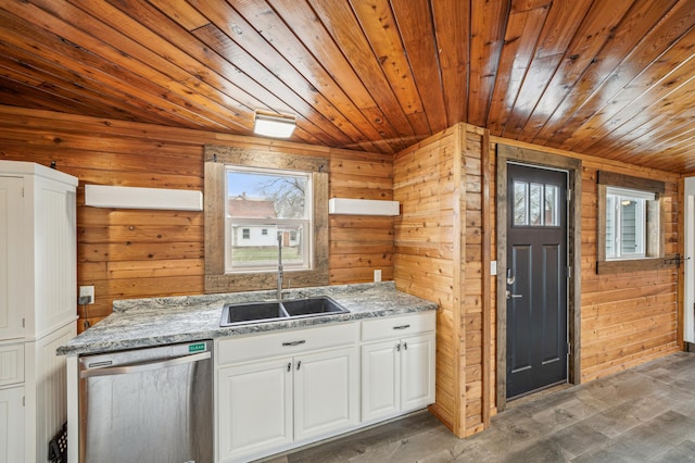kitchen with stainless steel dishwasher, wooden walls, a sink, and wooden ceiling