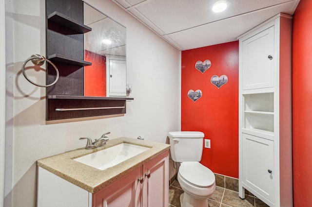 bathroom featuring toilet, vanity, and baseboards