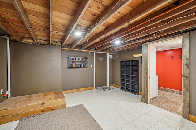 finished below grade area featuring baseboards and tile patterned flooring