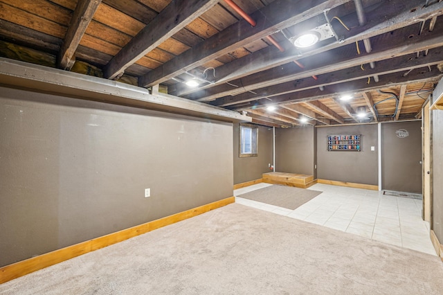 basement with tile patterned floors, carpet, and baseboards
