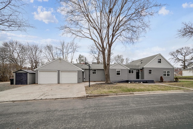 view of front of property with roof with shingles, an outdoor structure, driveway, a shed, and a garage