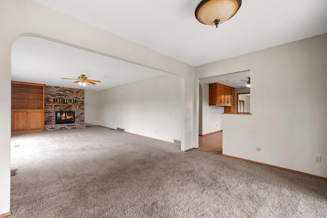 2591 Carver Ave E, Maplewood, MN 55119 - unfurnished living room featuring a ceiling fan, carpet, a fireplace, and baseboards