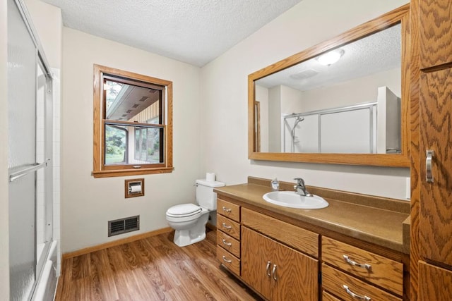 2591 Carver Ave E, Maplewood, MN 55119 - bathroom with a textured ceiling, vanity, toilet, wood finished floors, and baseboards