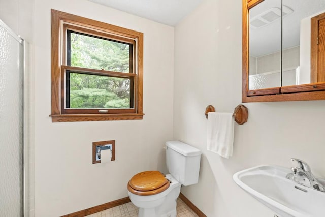 2591 Carver Ave E, Maplewood, MN 55119 - full bathroom with baseboards, toilet, a sink, and a shower