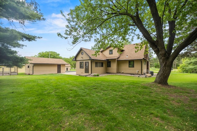 2591 Carver Ave E, Maplewood, MN 55119 - rear view of house featuring a lawn, central AC unit, roof with shingles, and board and batten siding