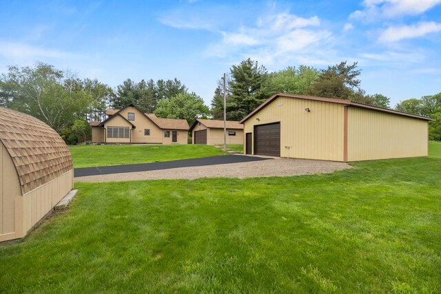2591 Carver Ave E, Maplewood, MN 55119 - view of grassy yard featuring a garage and an outbuilding