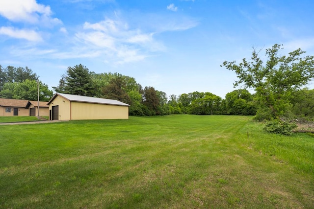 2591 Carver Ave E, Maplewood, MN 55119 - view of green lawn featuring an outdoor structure, a garage, a pole building, and view of scattered trees