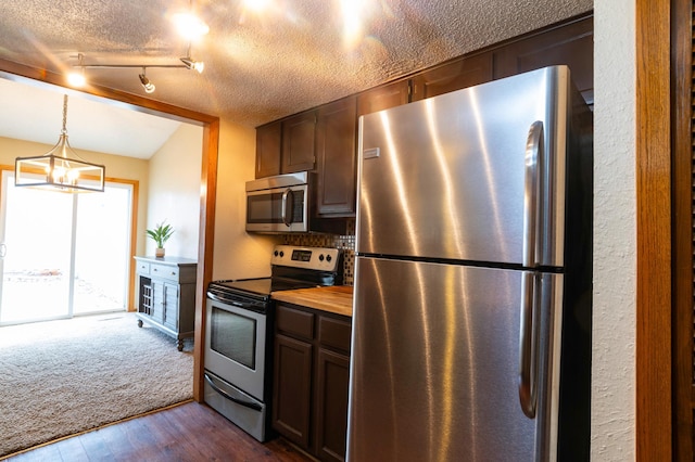 kitchen featuring a textured ceiling, stainless steel appliances, decorative light fixtures, a notable chandelier, and dark wood-type flooring