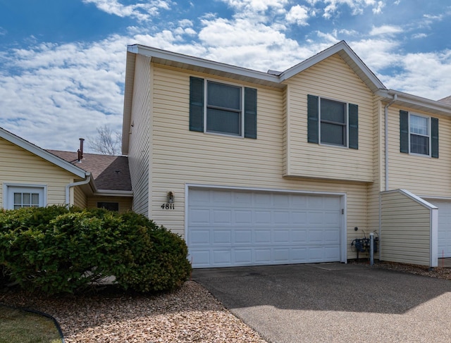 view of side of property with an attached garage and driveway