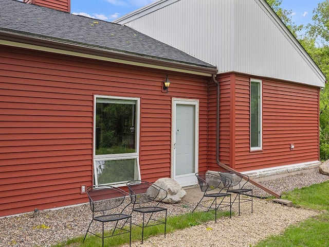 2595 Carver Ave E, Maplewood, MN 55119 - rear view of house with roof with shingles, a patio, and a chimney
