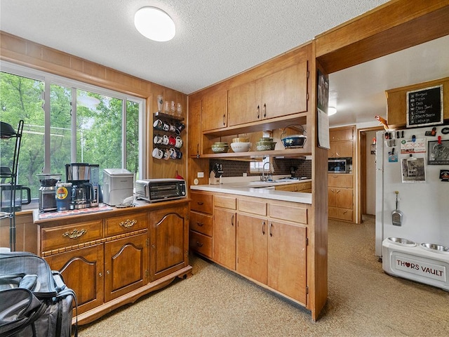 2595 Carver Ave E, Maplewood, MN 55119 - kitchen with freestanding refrigerator, open shelves, stainless steel microwave, light countertops, and a textured ceiling