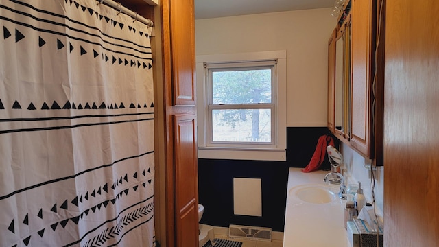 bathroom with visible vents, toilet, curtained shower, and vanity