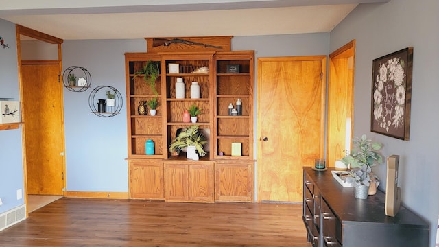 interior space with visible vents, baseboards, and wood finished floors