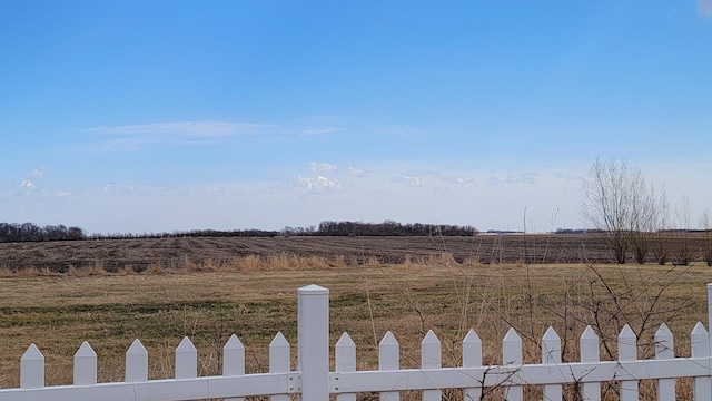view of yard featuring fence and a rural view