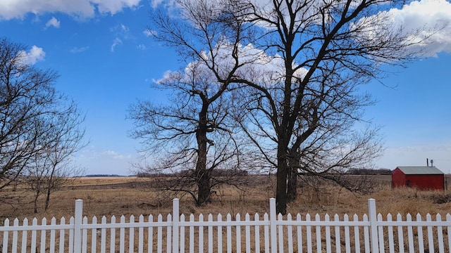 view of yard featuring an outbuilding, fence, and a storage unit