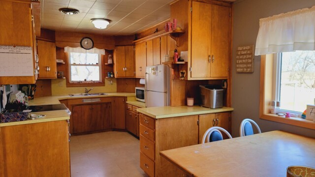 3100 380th St, Cottonwood, MN 56229 - kitchen featuring open shelves, a sink, white appliances, and brown cabinets