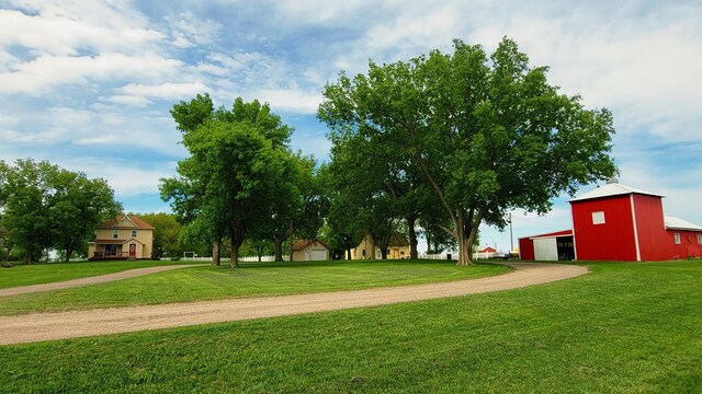 3100 380th St, Cottonwood, MN 56229 - view of home's community featuring dirt driveway, an outbuilding, a detached garage, and a lawn