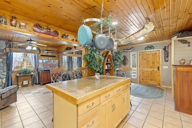45570 Star Lake Rd, Marcell, MN 56657 - kitchen featuring ceiling fan, wooden walls, a center island, light tile patterned floors, and wood ceiling