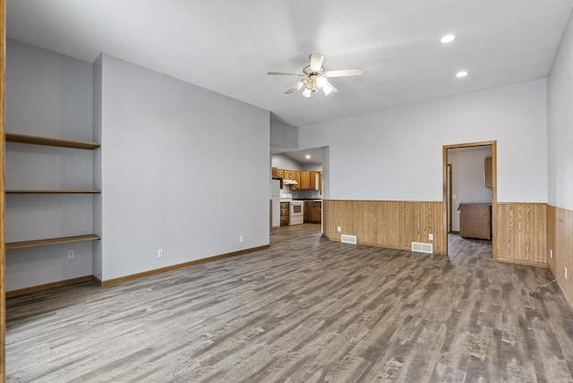 unfurnished living room featuring wainscoting, visible vents, a ceiling fan, and wood finished floors