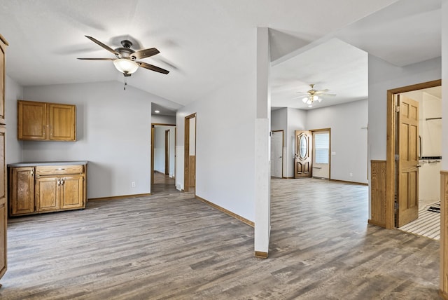 unfurnished living room featuring wood finished floors, baseboards, a ceiling fan, and lofted ceiling