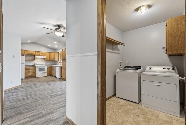 washroom with ceiling fan, washing machine and dryer, a sink, baseboards, and cabinet space