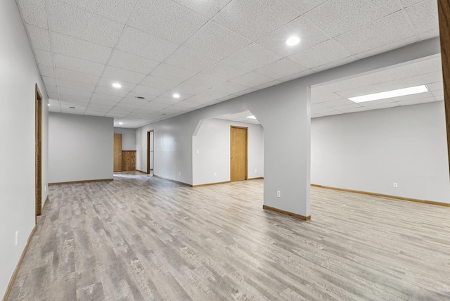basement featuring baseboards, recessed lighting, a paneled ceiling, and wood finished floors