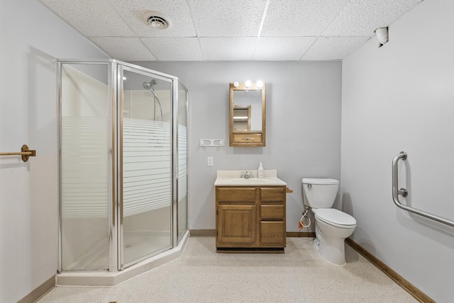 bathroom with toilet, baseboards, a stall shower, and a drop ceiling