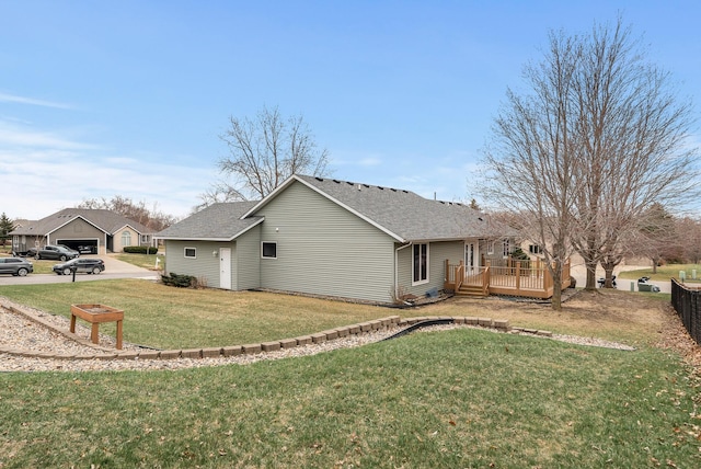 view of property exterior featuring a shingled roof, a deck, and a lawn