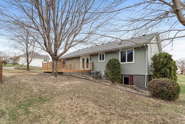 back of property with a deck, roof with shingles, and central AC unit