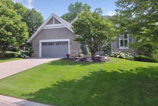 craftsman house featuring stone siding, driveway, a front yard, and a garage