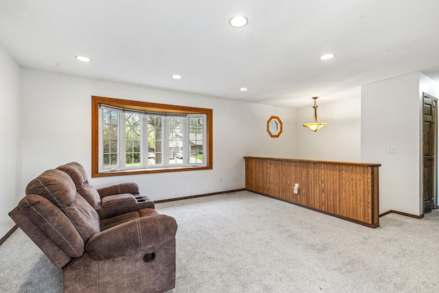 living area featuring baseboards, recessed lighting, and light colored carpet