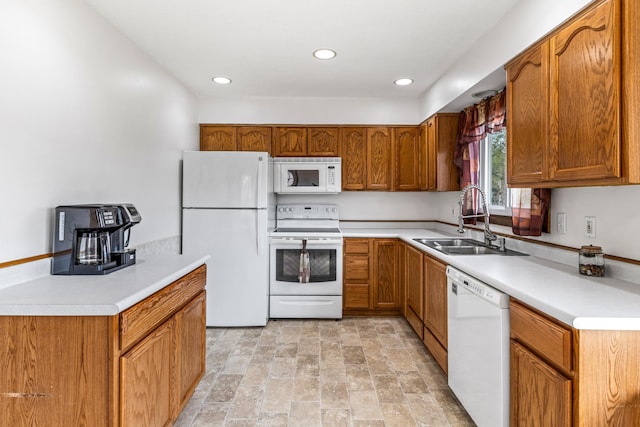 kitchen featuring brown cabinetry, stone finish flooring, a sink, light countertops, and white appliances