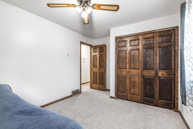 carpeted bedroom with baseboards, visible vents, and ceiling fan