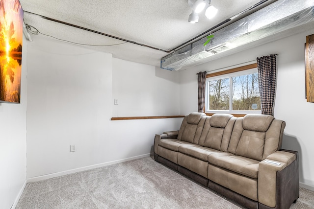 living room with carpet floors, baseboards, and a textured ceiling