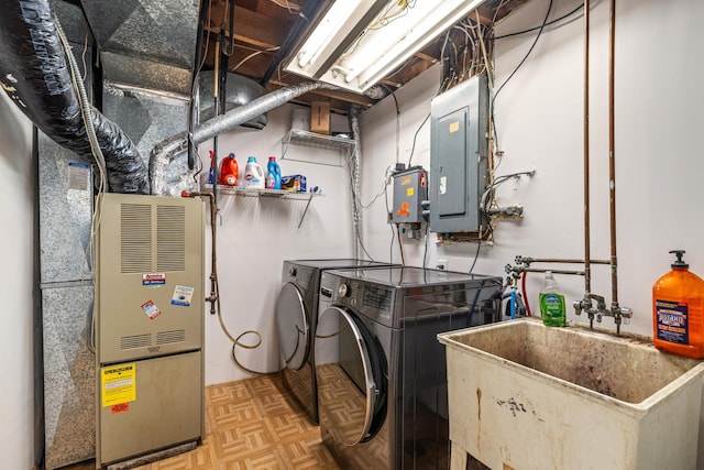 utilities with a sink, independent washer and dryer, and electric panel