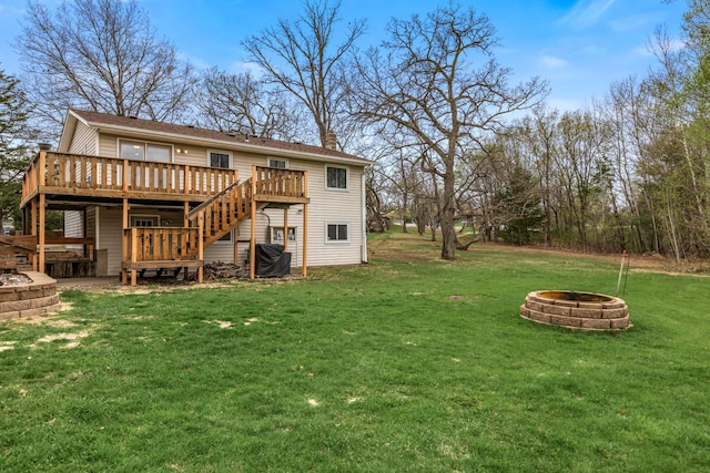 rear view of property featuring a wooden deck, a chimney, an outdoor fire pit, a yard, and stairway