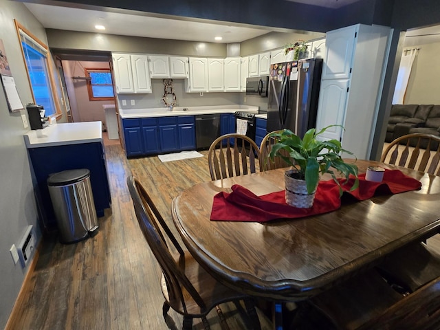1014 3rd Ave SW, Pipestone, MN 56164 - kitchen featuring dark wood finished floors, blue cabinetry, white cabinets, black appliances, and baseboards